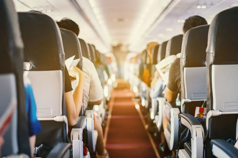 View down the center aisle of an airplane full of passengers